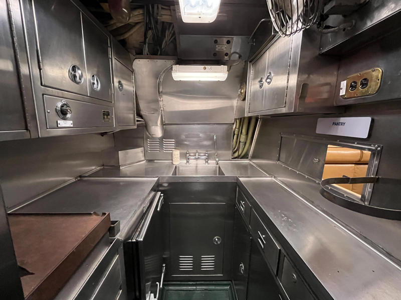 Officers' meals were cooked in the galley and served from the wardroom pantry. In the navigation compartment, crew members plotted courses and tracked Growler's position., The missile checkout and guidance center was once a top-secret area., Officers had access to their own shower., Officers used the wardroom to eat, socialize, and hold meetings., Yeomen handled clerical and administrative work aboard the USS Growler's tiny office., Here, the commanding officer would give orders to the crew., The sonar room also aided Growler's navigation., Crew members communicated with other ships in the radio room., Meals were prepared in the galley., In the scullery, Growler crew members washed dishes and compacted trash., The crew's mess was the only common space on the USS Growler., Growler's largest sleeping area contained 46 bunks., The crew's washroom featured two showers., Growler's three diesel engines were located in the engine room.