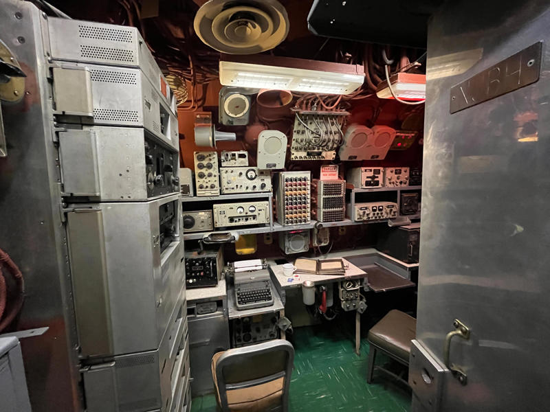 Crew members communicated with other ships in the radio room. In the navigation compartment, crew members plotted courses and tracked Growler's position., The missile checkout and guidance center was once a top-secret area., Officers had access to their own shower., Officers used the wardroom to eat, socialize, and hold meetings., Yeomen handled clerical and administrative work aboard the USS Growler's tiny office., Here, the commanding officer would give orders to the crew., The sonar room also aided Growler's navigation., Crew members communicated with other ships in the radio room., Meals were prepared in the galley., In the scullery, Growler crew members washed dishes and compacted trash., The crew's mess was the only common space on the USS Growler., Growler's largest sleeping area contained 46 bunks., The crew's washroom featured two showers., Growler's three diesel engines were located in the engine room.