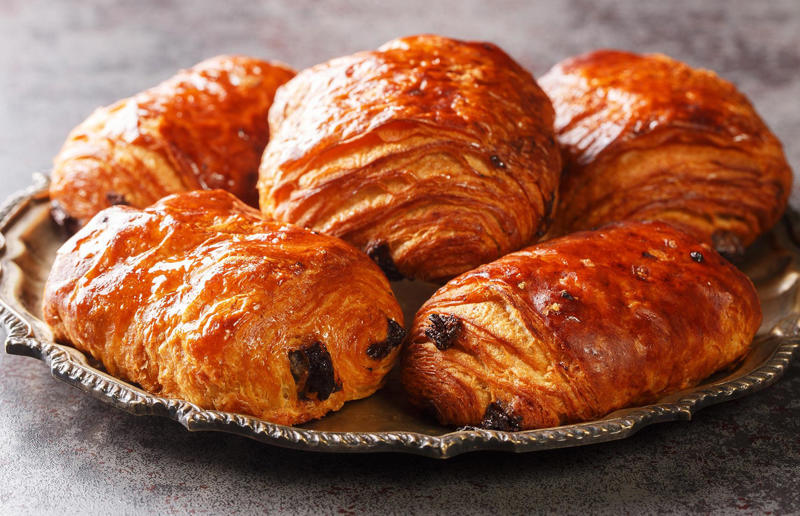 10: Pain au chocolat, France 37: Baklava, various locations, 36: Rolex, Uganda, 35: Dadar gulung, Indonesia, 34: Ta'ameya, Egypt, 33: Brownies, USA, 32: Plantain chips, various locations, 31: Koeksister, South Africa, 30: Ma'amoul, Egypt, 29: Takoyaki, Japan, 28: Rice Krispie treats, USA, 27: Poffertjes, Netherlands, 26: Haggis bon bons, Scotland, 25: Pão de queijo, Brazil, 24: Chocolate digestives, UK, 23: Churros, Spain, 22: Kartoffelpuffer, Germany, 21: Stroopwafel, Netherlands, 20: Mooncake, China, 19: Sausage roll, UK, 18: Biltong, South Africa, 17: Aloo tikki, India, 16: Qatayef, Middle East, 15: Lamington, Australia, 14: S'mores, USA, 13: Meat pie, Australia and New Zealand, 12: Lumpia, Indonesia and the Philippines, 11: Nanaimo bar, Canada, 10: Pain au chocolat, France, 9: Mochi, Japan, 8: Pani puri, India, 7: Doughnut, various locations, 6: Poutine, Canada, 5: Currywurst, Germany, 4: Macaron, France, 3: Nachos, Mexico, 2: Samosa, various locations