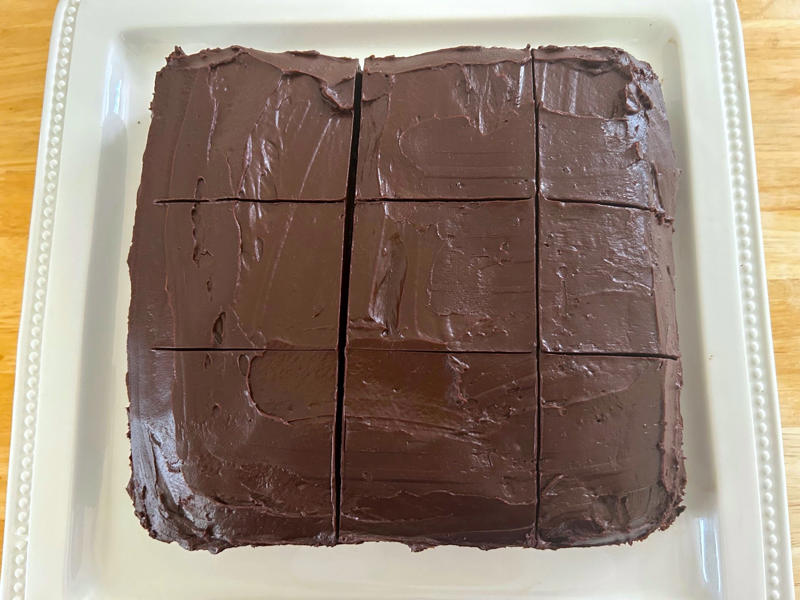 I cut my cake into squares just as Garten had, and voilà — it was ready to eat! Garten's chocolate cake features cocoa powder, espresso powder, and "good" vanilla., You'll also need some ingredients for the mocha frosting., I also prepped my dry ingredients ..., … and my chocolate-and-coffee mixture., It was time to start the batter., Then I added the vanilla and eggs., My cake batter was ready!, While my cake was cooling, I began making the frosting., I also prepped the cream., Once the cream was ready, I poured it over the chocolate mixture., Then I stirred in the Kahlúa and vanilla., I covered my frosting and refrigerated it for 30 minutes., It was time to frost my cake., Garten's chocolate cake with mocha icing tasted rich and decadent.