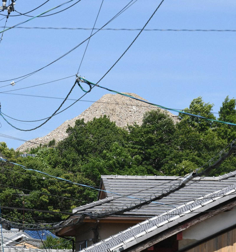 2階建て建物の屋根よりも高く積み上がった産廃物＝京都市伏見区で2026年6月10日、久保聡撮影, まるで山のように積み上がる産業廃棄物＝京都市伏見区で2026年6月10日、久保聡撮影, 積み上がった産廃物。コンクリ片なども混じっている＝京都市伏見区で2026年6月10日、久保聡撮影, 積み上がった産廃物。崩れそうになっている場所も＝京都市伏見区で2026年6月10日、久保聡撮影, 積み上がった産業廃棄物。すぐ近くには民間の建物も＝京都市伏見区で2026年6月10日、久保聡撮影, 山のように積み上がった産廃物＝京都市伏見区で2026年6月10日、久保聡撮影