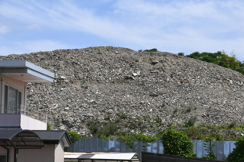 2階建て建物の屋根よりも高く積み上がった産廃物＝京都市伏見区で2026年6月10日、久保聡撮影, まるで山のように積み上がる産業廃棄物＝京都市伏見区で2026年6月10日、久保聡撮影, 積み上がった産廃物。コンクリ片なども混じっている＝京都市伏見区で2026年6月10日、久保聡撮影, 積み上がった産廃物。崩れそうになっている場所も＝京都市伏見区で2026年6月10日、久保聡撮影, 積み上がった産業廃棄物。すぐ近くには民間の建物も＝京都市伏見区で2026年6月10日、久保聡撮影, 山のように積み上がった産廃物＝京都市伏見区で2026年6月10日、久保聡撮影
