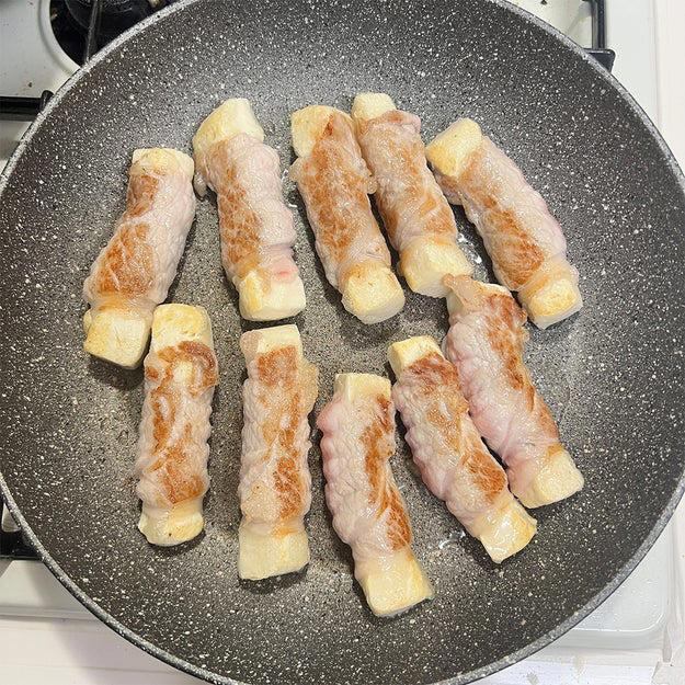 肉巻き豆腐の照り焼き, 作り方： ① 木綿豆腐はキッチンペーパーで包み、耐熱皿にのせて600Wの電子レンジで3分加熱して水切りする。粗熱が取れたら、半分の厚さに切り重ねたまま横に置き更に5等分の幅に切る。, ② バットに片栗粉を入れて①をまぶしたら、1本ずつ豚ロース肉で巻く。, ③ フライパンにサラダ油（分量外、大さじ1程度）を引き、中火で熱する。②を並べて全体的にこんがりと焼き色をつける。, ④ 合わせた【A】を加えて煮からめたら、完成！, 濃いめの味付けだからメイン料理にもオススメ◎