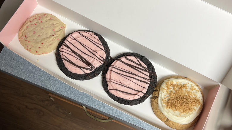 You can buy single cookies or in packs You can buy single cookies or in packs, Some locations stay open until midnight, Cookies are served warm or chilled, You can get cookies delivered or order catering, The cookies are very sweet, You can purchase a cookie cutter for convenient sharing, Keep an eye out for any promotions, Ask for a sticker with your purchase, The pink box is an iconic part of the Crumbl experience
