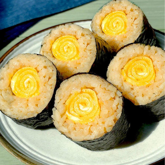 作り方：① 炊飯釜に【A】を入れ、２合の目盛りまで水（分量外、適量）を注いで炊飯する。, ② 卵焼き器にサラダ油を半量引いて中火に熱し、混ぜ合わせた【B】を流し入れて全体に広げる。表面が半熟状になるまで焼き、奥から手前に巻く。同様にもう1つ作る。, ③ 焼きのり1枚をラップの上にのせる。上部3cmほどを残して①の半量を全体に広げ、②をのせて巻く。同様にもう1本作る。ぬらした包丁で食べやすい大きさに切ったら、完成！, おにぎりよりこっちがいい！！