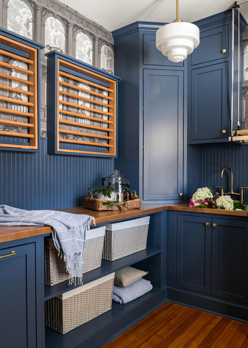 Embrace a color-drenching moment, Say yes to spray paint, Just add curtains, Nod to location, Work your vertical space, Don’t overlook the floor, Use a sliding door, Don’t hold back on detail, Add a clothing rod, Create a multiuse space, Add color with a bold wallpaper, Plan around storage, Don’t forget the art, Install high shelving, Put every flat surface to use, Incorporate hampers for easy organization, Put a drying rack on the wall, It’s okay to cover windows, Keep laundry materials out of sight, Create a dual mudroom, Built-in furniture is not the only path to success, Place pattern all over, Install a unique light fixture, Place cabinets on top of your washer/dryer, Add texture with cabinet fronts, Hide away your washer and dryer, Camouflage appliances, Go for sliding racks, Lean into neutrals, Add a countertop to a galley laundry room, Choose a vibrant color scheme, Play with geometry, Opt for moody elegance