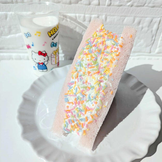 Xで話題になっている、セブンの“あるスイーツ”を買ってみました！, チョコスプレーがふんだんにトッピングされた、欲張りなサンドイッチ！, ホイップクリームがたっぷりで分厚いんです。, カラフルなチョコスプレーがかわいい。, チョコスプレーの懐かしい味を堪能できますよ。, ホイップクリームは、さっぱりしていてクドくない。, ふわふわのパンとクリームのバランスがちょうどいい。, 子どもの頃の夢が叶う、特別感のあるサンドイッチでした。