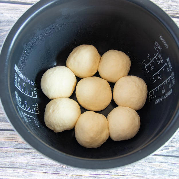 オーブン不要！ 炊飯器でふわっふわのちぎりパン, レシピの基本情報：, 作り方：① 耐熱ボウルに牛乳を入れ、ふんわりとラップをかけて600Wの電子レンジで30秒加熱する。, ② ①にドライイーストを入れて混ぜ合わせる。, ③ 別のボウルに【A】を入れて混ぜ、②を加えてひとまとまりになるまでこねる。バターを加えてさらにこね、表面が張るように丸める。, ④ ふんわりとラップをかけ、2倍の大きさになるまで1時間ほどおく。, ⑤ ④をこぶしで押してガスを抜き、8等分にして表面が張るように丸める。内釜に並べてふたをし、1.5倍の大きさになるまで40分ほどおく。, ⑥ きな粉と砂糖を混ぜたものを⑤に茶こしで振りかけ、通常通り炊飯する。炊き上がったらすぐに内釜から取り出し、粗熱がとれたら、完成！