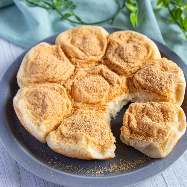 オーブン不要！ 炊飯器でふわっふわのちぎりパン, レシピの基本情報：, 作り方：① 耐熱ボウルに牛乳を入れ、ふんわりとラップをかけて600Wの電子レンジで30秒加熱する。, ② ①にドライイーストを入れて混ぜ合わせる。, ③ 別のボウルに【A】を入れて混ぜ、②を加えてひとまとまりになるまでこねる。バターを加えてさらにこね、表面が張るように丸める。, ④ ふんわりとラップをかけ、2倍の大きさになるまで1時間ほどおく。, ⑤ ④をこぶしで押してガスを抜き、8等分にして表面が張るように丸める。内釜に並べてふたをし、1.5倍の大きさになるまで40分ほどおく。, ⑥ きな粉と砂糖を混ぜたものを⑤に茶こしで振りかけ、通常通り炊飯する。炊き上がったらすぐに内釜から取り出し、粗熱がとれたら、完成！