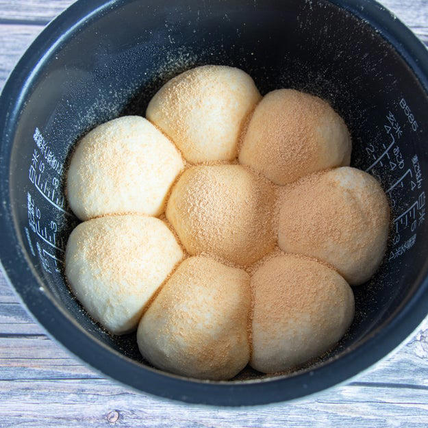 オーブン不要！ 炊飯器でふわっふわのちぎりパン, レシピの基本情報：, 作り方：① 耐熱ボウルに牛乳を入れ、ふんわりとラップをかけて600Wの電子レンジで30秒加熱する。, ② ①にドライイーストを入れて混ぜ合わせる。, ③ 別のボウルに【A】を入れて混ぜ、②を加えてひとまとまりになるまでこねる。バターを加えてさらにこね、表面が張るように丸める。, ④ ふんわりとラップをかけ、2倍の大きさになるまで1時間ほどおく。, ⑤ ④をこぶしで押してガスを抜き、8等分にして表面が張るように丸める。内釜に並べてふたをし、1.5倍の大きさになるまで40分ほどおく。, ⑥ きな粉と砂糖を混ぜたものを⑤に茶こしで振りかけ、通常通り炊飯する。炊き上がったらすぐに内釜から取り出し、粗熱がとれたら、完成！
