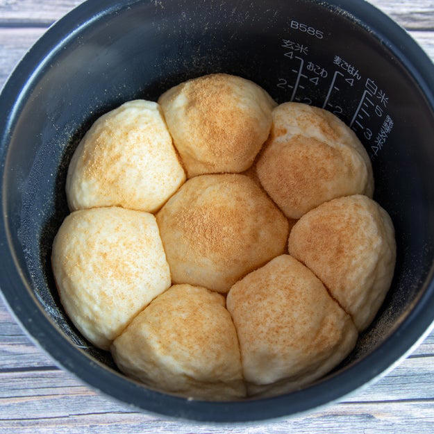 オーブン不要！ 炊飯器でふわっふわのちぎりパン, レシピの基本情報：, 作り方：① 耐熱ボウルに牛乳を入れ、ふんわりとラップをかけて600Wの電子レンジで30秒加熱する。, ② ①にドライイーストを入れて混ぜ合わせる。, ③ 別のボウルに【A】を入れて混ぜ、②を加えてひとまとまりになるまでこねる。バターを加えてさらにこね、表面が張るように丸める。, ④ ふんわりとラップをかけ、2倍の大きさになるまで1時間ほどおく。, ⑤ ④をこぶしで押してガスを抜き、8等分にして表面が張るように丸める。内釜に並べてふたをし、1.5倍の大きさになるまで40分ほどおく。, ⑥ きな粉と砂糖を混ぜたものを⑤に茶こしで振りかけ、通常通り炊飯する。炊き上がったらすぐに内釜から取り出し、粗熱がとれたら、完成！