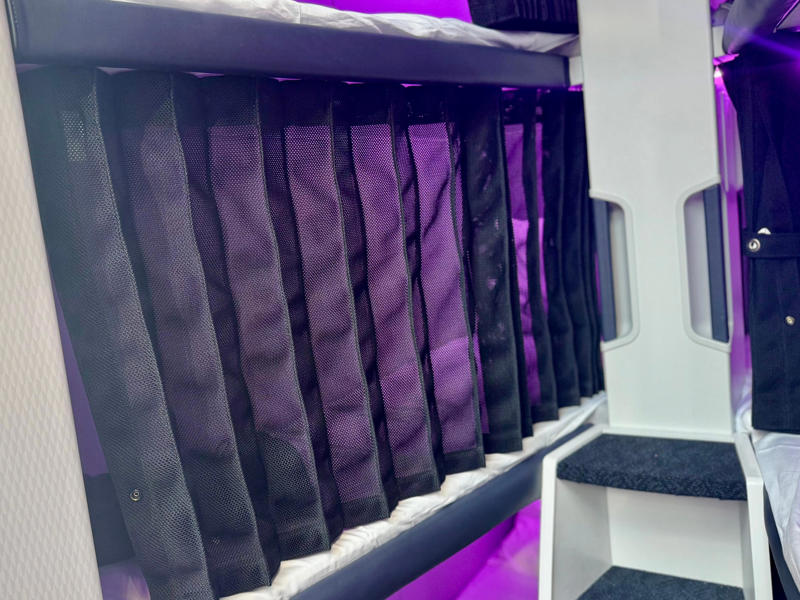 It features curtains, power, and a seatbelt. The Skynest will be located in the middle of the plane., It features curtains, power, and a seatbelt., Flyers get soft linens and an amenity kit., I'd prefer the bottom or middle bunks., Flyers will eat before or after their block., You must be 15 or older., I'd book the Skynest to fight jet lag., The Skynest is ANZ's second economy bed.