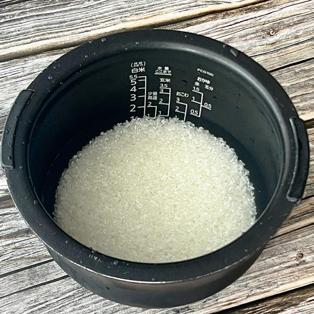 新玉ねぎの炊き込みご飯, 作り方：① 炊飯釜に研いだ米と【A】、水（分量外）を2合の目盛りまで水を注ぐ。, ② ①に皮をむいて、十字に切り込みを入れた新玉ねぎを入れて、通常通り炊飯する。, ③ 炊き上がったら軽くかき混ぜ、器に盛って小ねぎとかつお節をかけたら、完成！