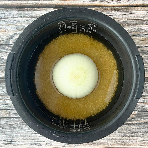新玉ねぎの炊き込みご飯, 作り方：① 炊飯釜に研いだ米と【A】、水（分量外）を2合の目盛りまで水を注ぐ。, ② ①に皮をむいて、十字に切り込みを入れた新玉ねぎを入れて、通常通り炊飯する。, ③ 炊き上がったら軽くかき混ぜ、器に盛って小ねぎとかつお節をかけたら、完成！