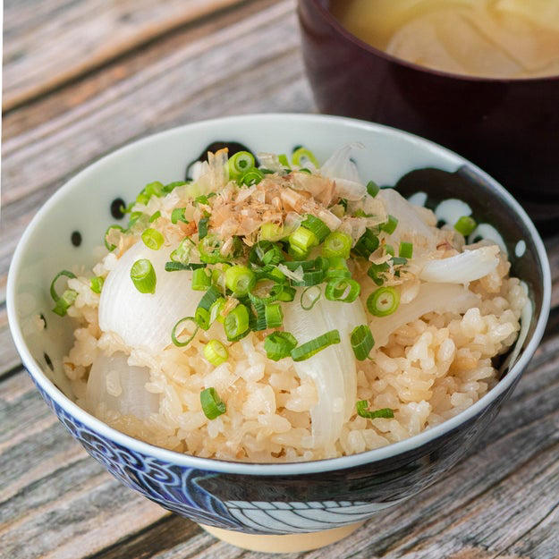 新玉ねぎの炊き込みご飯, 作り方：① 炊飯釜に研いだ米と【A】、水（分量外）を2合の目盛りまで水を注ぐ。, ② ①に皮をむいて、十字に切り込みを入れた新玉ねぎを入れて、通常通り炊飯する。, ③ 炊き上がったら軽くかき混ぜ、器に盛って小ねぎとかつお節をかけたら、完成！