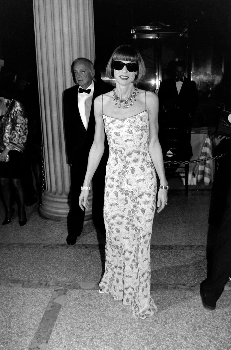Wintour wore a sparkly gold top for the 1989 Met Gala., Wintour arrived in an angelic Christian Dior ensemble for the 2003 Met Gala., Wintour dazzled at the 2010 Met Gala in a silver-tiered Chanel dress., She returned to wearing Chanel at the 2022 Met Gala, emphasizing "Gilded Glamour."