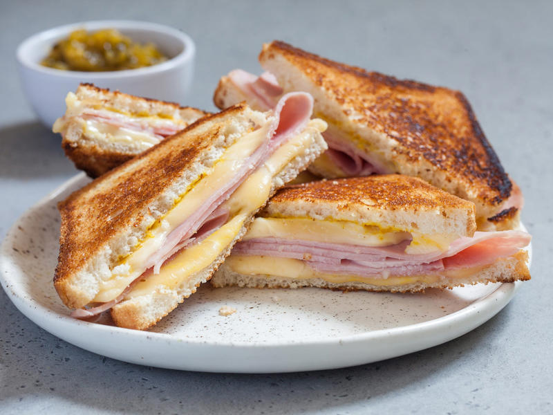 VIRGINIA: A grilled ham and cheese ALABAMA: A chicken sandwich with white barbecue sauce, ALASKA: A wild Alaskan salmon sandwich, ARIZONA: Frybread tacos, ARKANSAS: A deep-fried catfish sandwich, CALIFORNIA: An avocado club sandwich, COLORADO: A Denver sandwich, CONNECTICUT: A Connecticut hamburger, DELAWARE: A soft-shell fried crab sandwich, FLORIDA: A Cuban sandwich, GEORGIA: A fried chicken sandwich, HAWAII: A Kālua-style pork sandwich, ILLINOIS: A Horseshoe sandwich, INDIANA: A Hoosier sandwich, IOWA: A Tavern or "loose meat" sandwich, KANSAS: "Runza" or "bierocks", KENTUCKY: A Hot Brown sandwich, LOUISIANA: A po'boy, MARYLAND: A crab-cake sandwich, MASSACHUSETTS: A Fluffernutter, MICHIGAN: A corned beef sandwich, MINNESOTA: A Jucy Lucy, MISSISSIPPI: A pig-ear sandwich, MISSOURI: A Gerber sandwich, MONTANA: A PB&J with huckleberry jam, NEBRASKA: A Reuben, NEVADA: A Heart Attack Grill burger, NEW HAMPSHIRE: A fried ham and cheese Monte Cristo drizzled with syrup, NEW JERSEY: A Jersey breakfast sandwich, NEW MEXICO: A green chile cheeseburger, NORTH CAROLINA: A pulled-pork sandwich, NORTH DAKOTA: Smørbrød, OHIO: A Polish boy, OKLAHOMA: A chicken-fried steak sandwich, OREGON: A falafel pita, PENNSYLVANIA: A Philly cheesesteak, RHODE ISLAND: A Dynamite sandwich, SOUTH CAROLINA: A tuna melt, SOUTH DAKOTA: A walleye sandwich, TENNESSEE: A Fluffernutter, TEXAS: A brisket sandwich, UTAH: A pastrami burger, VERMONT: A Vermonter, VIRGINIA: A grilled ham and cheese, WASHINGTON: Bánh mì, WEST VIRGINIA: An apple and turkey sandwich, WISCONSIN: A sausage roll or brat bun, WYOMING: A bison meatball sandwich