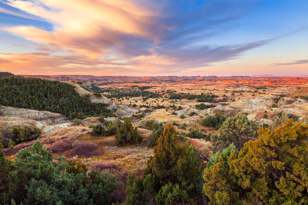 North Dakota: Theodore Roosevelt National Park Illinois: Garden of the Gods, Indiana: Indiana Dunes National Lakeshore, Iowa: Maquoketa Caves, Michigan: Kitch-iti-Kipi, Minnesota: Palisade Head, Nebraska: Platte River, North Carolina: Chimney Rock, North Dakota: Theodore Roosevelt National Park, Oregon: Crater Lake, Rhode Island: Mohegan Bluffs, South Carolina: Hunting Island, South Dakota: Badlands National Park, Utah: Bryce Canyon, Vermont: Lake Willoughby, Virginia: Natural Bridge, Washington: Blanca Lake