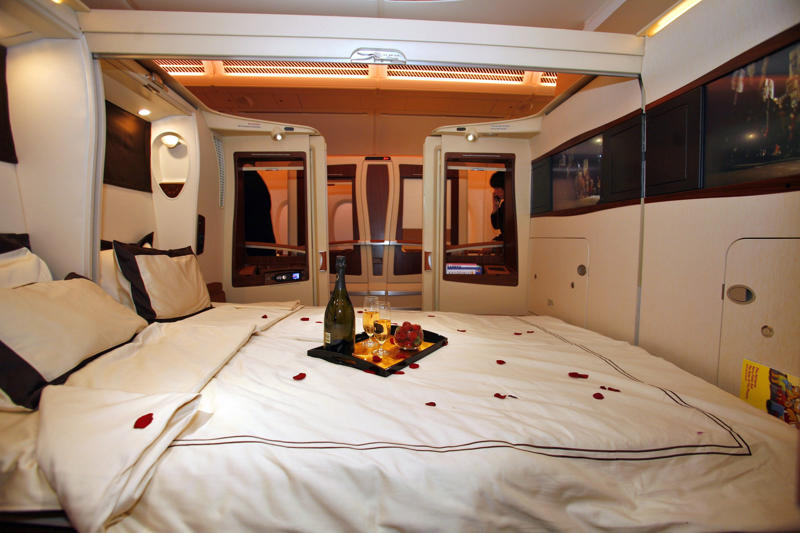 Reclining seats included footrests and leaned almost all the way back., The first-class cabin's gourmet dining remained., Flutes of Champagne were an added bonus., Spiral staircases led to the 747's upper deck lounge., Some early jumbo jets were even equipped with pianos., The massive double-decker entered service with Singapore Airlines in 2007., Two suites could even be merged to create a couple's suite., Emirates has also launched its own first-class suites., Amenities include access to an in-flight shower., However, the ultimate first-class experience comes courtesy of Etihad., Each 125-square-foot, three-room suite features an en suite bathroom with a shower., It also includes a private bedroom and a personal butler., Two suites can be joined to create a two-passenger mega-suite.