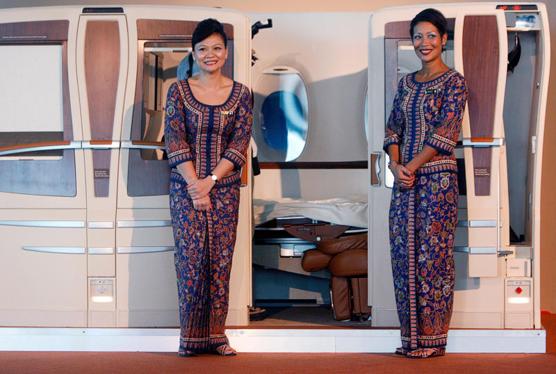 Reclining seats included footrests and leaned almost all the way back., The first-class cabin's gourmet dining remained., Flutes of Champagne were an added bonus., Spiral staircases led to the 747's upper deck lounge., Some early jumbo jets were even equipped with pianos., The massive double-decker entered service with Singapore Airlines in 2007., Two suites could even be merged to create a couple's suite., Emirates has also launched its own first-class suites., Amenities include access to an in-flight shower., However, the ultimate first-class experience comes courtesy of Etihad., Each 125-square-foot, three-room suite features an en suite bathroom with a shower., It also includes a private bedroom and a personal butler., Two suites can be joined to create a two-passenger mega-suite.