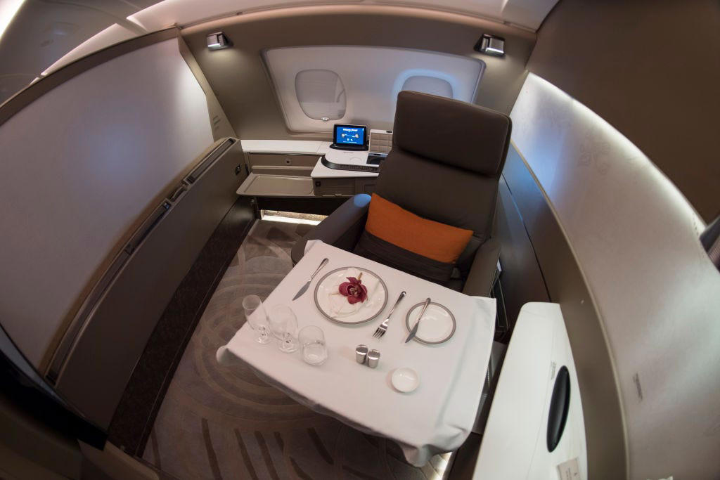 Reclining seats included footrests and leaned almost all the way back., The first-class cabin's gourmet dining remained., Flutes of Champagne were an added bonus., Spiral staircases led to the 747's upper deck lounge., Some early jumbo jets were even equipped with pianos., The massive double-decker entered service with Singapore Airlines in 2007., Two suites could even be merged to create a couple's suite., Emirates has also launched its own first-class suites., Amenities include access to an in-flight shower., However, the ultimate first-class experience comes courtesy of Etihad., Each 125-square-foot, three-room suite features an en suite bathroom with a shower., It also includes a private bedroom and a personal butler., Two suites can be joined to create a two-passenger mega-suite.