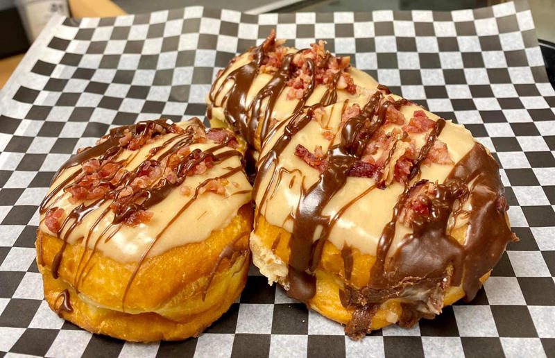 North Dakota: The Elvis, Bearscat Bakehouse, various locations Bacon with EVERYTHING, Alabama: BALT, Urban Cookhouse, various locations, Alaska: Fat Elvis milkshake, Snow City Cafe, Anchorage, Arizona: stuffed Medjool dates, J.T. Prime Kitchen & Cocktails, Yuma, Arkansas: Eggniter, Golden Kolache Bakery, Fayetteville, California: B’B’B’ Bacon, Slater's 50/50, various locations, Colorado: signature bacon flight, Bacon Social House, various locations, Connecticut: smoked mac & cheese, Pig Rig BBQ, Wallingford, Delaware: bacon cheese fries, m2o Burgers & Salads, Newark, District of Columbia: glazed bacon lollis, Founding Farmers, various locations, Florida: candied bacon maple ice cream, Ulele, Tampa, Georgia: BBQ bacon, Burger 21, Kennesaw and Buford, Hawaii: Fat Boy, Hank's Haute Dogs, Honolulu, Idaho: bacon, egg, and cheese breakfast tacos, Tin Roof Tacos, various locations, Illinois: cheeseburger, Au Cheval, Chicago, Indiana: BLT croissant, Rize, various locations, Iowa: pancake sandwich, The Breakfast Club, various locations, Kansas: bleu cheese and bacon burger, The Anchor, Wichita, Kentucky: maple bacon donut, Nord's Bakery, Louisville, Louisiana: Buckboard Bacon Melt, Cochon Butcher, New Orleans, Maine: bacon Cheddar, The Holy Donut, Portland, Maryland: Baltimore Burger, Abbey Burger Bistro, Baltimore and Havre de Grace, Massachusetts: 'Irish' nachos, Harry's Bar & Grill, Boston, Michigan: BLT, Tony’s I-75, Birch Run, Minnesota: Millionaire bacon burger, Granite City Food & Brewery, various locations, Mississippi: Redneck Benny, Big Bad Breakfast, Oxford, Missouri: The Combo, Songbird, St. Louis, Montana: The 'Mazatlan' Mexican Dog, The Burger Dive, Billings, Nebraska: Greatest Burger Ever, Honest Abe’s Burgers & Freedom, Lincoln, Nebraska, Nevada: 24K Burger, Slater's 50/50, Las Vegas, New Hampshire: Bacon Bene, The Bacon Barn, Londonderry, New Jersey: bacon brisket sandwich, Bake'n Bacon, Cape May, New Mexico: BB&C, Urban Hotdog Company, Albuquerque, New York: Clothesline Bacon, David Burke Tavern, New York City, North Carolina: BLT, Merritt's Grill, Chapel Hill, North Dakota: The Elvis, Bearscat Bakehouse, Bismarck and Minot, Ohio: Biscuit BLT, Dough Mama, Columbus, Oklahoma: Brussels sprouts, Packard’s, Oklahoma City, Oregon: praline bacon, Screen Door, Portland, Pennsylvania: bacon flight, Bacon, Bourbon & Beer, Washington, Rhode Island: BLT, The Malted Barley, Providence, South Carolina: candied bacon brownie, Nose Dive, Greenville, South Dakota: bacon wrapped filet mignon, Alpine Inn, Hill City, Tennessee: Southern Sampler Breakfast, The Loveless Cafe, Nashville, Texas: chicken fried bacon, Sodolak's Original Country Inn, Snook, Utah: roasted bacon wrapped dates, Midway Mercantile Restaurant, Midway, Vermont: Breakfast Mac, Our House Bistro, Winooski, Virginia: Mother Clucker, Capitol Waffle Shop, various locations, Washington: Meatza, Windy City Pie, Seattle, West Virginia: hot chicken sandwich with bacon, Wood Iron Eatery, Fayetteville, Wisconsin: tequila jam burger, 11:11 Burgers & Beignets, Fond Du Lac, Wisconsin