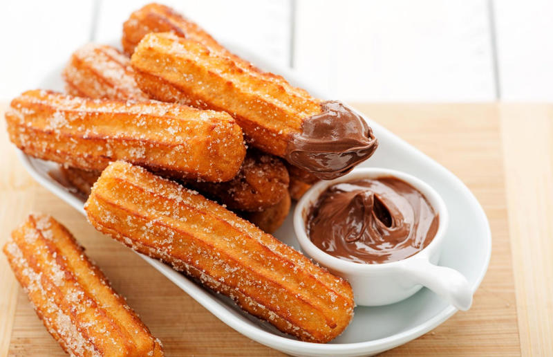 20. Churros, Spain 37: Baklava, various locations, 36: Rolex, Uganda, 35: Dadar gulung, Indonesia, 34: Ta'ameya, Egypt, 33: Brownies, USA, 32: Plantain chips, various locations, 31: Koeksister, South Africa, 30: Ma'amoul, Egypt, 29: Takoyaki, Japan, 28: Rice Krispie treats, USA, 27: Poffertjes, Netherlands, 26: Haggis bon bons, Scotland, 25: Pão de queijo, Brazil, 24: Chocolate digestives, UK, 23: Churros, Spain, 22: Kartoffelpuffer, Germany, 21: Stroopwafel, Netherlands, 20: Mooncake, China, 19: Sausage roll, UK, 18: Biltong, South Africa, 17: Aloo tikki, India, 16: Qatayef, Middle East, 15: Lamington, Australia, 14: S'mores, USA, 13: Meat pie, Australia and New Zealand, 12: Lumpia, Indonesia and the Philippines, 11: Nanaimo bar, Canada, 10: Pain au chocolat, France, 9: Mochi, Japan, 8: Pani puri, India, 7: Doughnut, various locations, 6: Poutine, Canada, 5: Currywurst, Germany, 4: Macaron, France, 3: Nachos, Mexico, 2: Samosa, various locations