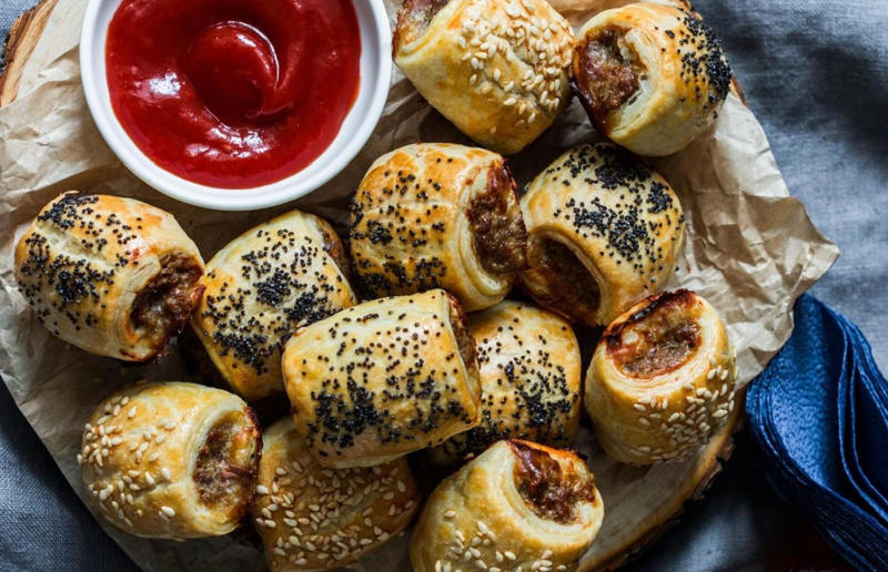 16. Sausage roll, UK 37: Baklava, various locations, 36: Rolex, Uganda, 35: Dadar gulung, Indonesia, 34: Ta'ameya, Egypt, 33: Brownies, USA, 32: Plantain chips, various locations, 31: Koeksister, South Africa, 30: Ma'amoul, Egypt, 29: Takoyaki, Japan, 28: Rice Krispie treats, USA, 27: Poffertjes, Netherlands, 26: Haggis bon bons, Scotland, 25: Pão de queijo, Brazil, 24: Chocolate digestives, UK, 23: Churros, Spain, 22: Kartoffelpuffer, Germany, 21: Stroopwafel, Netherlands, 20: Mooncake, China, 19: Sausage roll, UK, 18: Biltong, South Africa, 17: Aloo tikki, India, 16: Qatayef, Middle East, 15: Lamington, Australia, 14: S'mores, USA, 13: Meat pie, Australia and New Zealand, 12: Lumpia, Indonesia and the Philippines, 11: Nanaimo bar, Canada, 10: Pain au chocolat, France, 9: Mochi, Japan, 8: Pani puri, India, 7: Doughnut, various locations, 6: Poutine, Canada, 5: Currywurst, Germany, 4: Macaron, France, 3: Nachos, Mexico, 2: Samosa, various locations