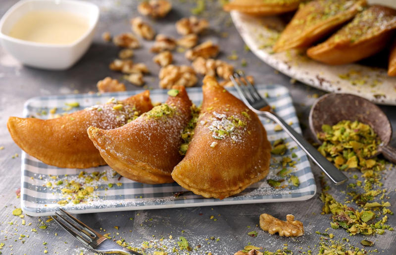 14. Qatayef, Middle East 37: Baklava, various locations, 36: Rolex, Uganda, 35: Dadar gulung, Indonesia, 34: Ta'ameya, Egypt, 33: Brownies, USA, 32: Plantain chips, various locations, 31: Koeksister, South Africa, 30: Ma'amoul, Egypt, 29: Takoyaki, Japan, 28: Rice Krispie treats, USA, 27: Poffertjes, Netherlands, 26: Haggis bon bons, Scotland, 25: Pão de queijo, Brazil, 24: Chocolate digestives, UK, 23: Churros, Spain, 22: Kartoffelpuffer, Germany, 21: Stroopwafel, Netherlands, 20: Mooncake, China, 19: Sausage roll, UK, 18: Biltong, South Africa, 17: Aloo tikki, India, 16: Qatayef, Middle East, 15: Lamington, Australia, 14: S'mores, USA, 13: Meat pie, Australia and New Zealand, 12: Lumpia, Indonesia and the Philippines, 11: Nanaimo bar, Canada, 10: Pain au chocolat, France, 9: Mochi, Japan, 8: Pani puri, India, 7: Doughnut, various locations, 6: Poutine, Canada, 5: Currywurst, Germany, 4: Macaron, France, 3: Nachos, Mexico, 2: Samosa, various locations