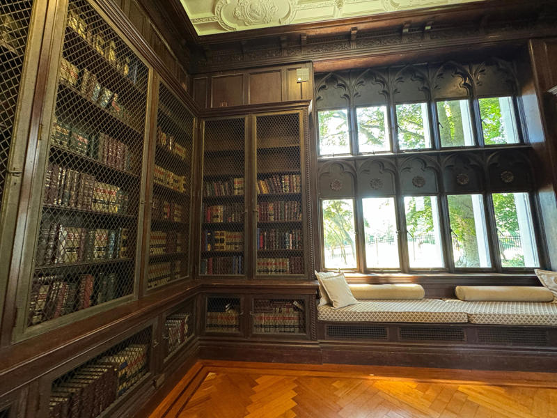 Next to the living room is the library, which has a window seat that looks perfect for lounging on. It also features the largest fireplace in the home., The billiards room also has a luxurious window seat., Directly next to the breakfast room was another wood-paneled study., It has yet another perfect window seat., It's also one of the only rooms with a private bathroom., We stopped at one more guest room, which was more modest., As the tour concluded, we were able to explore the gardens outside.
