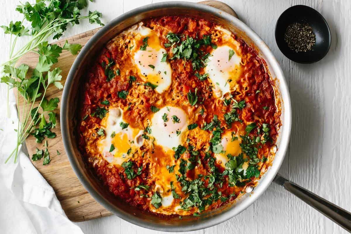 Shakshuka, Israel, 1. Mohinga, Myanmar, 2. Haleem, Iran, 3. Shakshuka, Israel, 4. Kanapki, Polandia, 5. Burek, Bosnia, 6. Idli, India, 7. Youtiao, Tiongkok, 8. Msemen, Maroko, 9. Arepa, Venezuela, 10. Crumpet, Inggris Raya, 11. Mandazi, Kenya, 12. Manakish, Lebanon, 13. Genfo, Etiopia, 14. Kanelbulle, Swedia