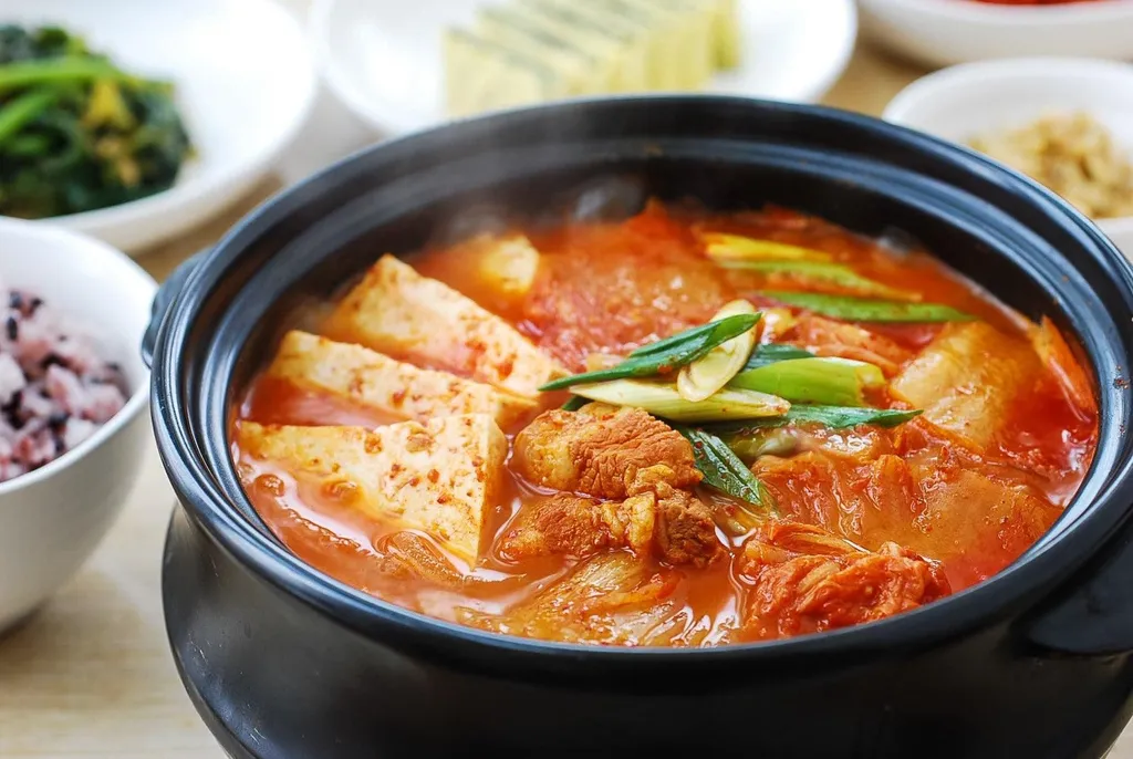Kimchi Jiigae (Sup Kimchi), 1. Tteokbokki (Spicy Rice Cakes), 2. Buldak (Fire Chicken), 3. Maeundae Galbi Jjim (Iga Rebus Pedas), 4. Nakji Bokkeum (Gurita Pedas), 5. Dakbal (Ceker Pedas), 6. Maeun Jokbal (Daging Babi Pedas), 7. Ramyeon (Mie Instan Pedas Korea), 8. Kimchi Jiigae (Sup Kimchi), 9. Budae Jjigae (Sup Campur Pedas), 10. Jjampong (Mie Seafood Pedas)