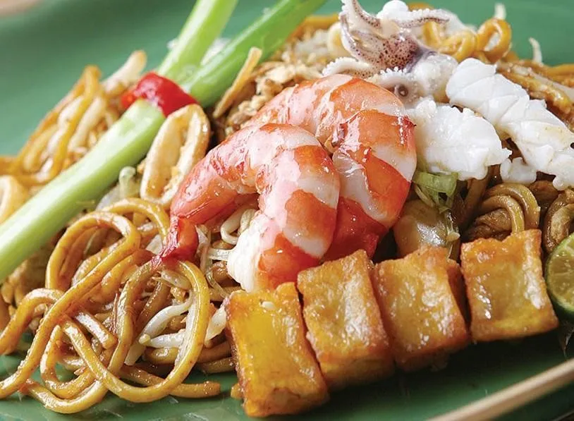 Malay Mee Goreng, 1. Roti Canai Tissue with Milk and Cheese, 2. Roti Canai with Chicken Curry, 3. Fried Tofu Negeri Jiran, 4. Malay Mee Goreng, 5. Malaysian Chicken Satay, 6. Mango Chicken, 7. Clay Pot Curry Prawn, 8. Singapore Laksa Udon, 9. Durian Chendol, 10. Teh Tarik Frappe