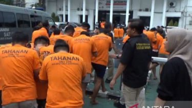 Polisi menggiring puluhan tersangka pesta seks gay di Surabaya ke ruang tahanan