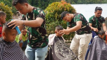 Prajurit TNI Bantu Cukur Rambut Gratis Anak Pengungsi Bencana di Tapanuli Utara