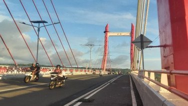Warga Kota Ambon melintasi Jembatan Merah Putih yang ikonik