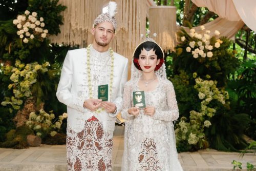 1. Jennifer tampil anggun dengan kebaya putih berhiaskan payet, 2. Riasan paes memperkuat nuansa adat Jawa, 3. Sanggul klasik dihiasi aksen bunga merah, 4. Justin Hubner tampil gagah dengan beskap putih, 5. Blangkon dan ronce melati melengkapi penampilan, Top 5+ Gaya Akad Nikah Jennifer Coppen dan Justin Hubner, Balutan Adat Jawa