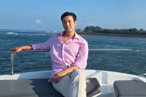1. Menikmati momen santai di pantai, Siwon pakai kemeja biru muda dipadukan celana pendek warna putih serta kacamata lensa biru., 2. Siwon berpose di kamar hotel mengenakan kaos polo warna merah dengan celana pendek serta Birkenstock Z&uuml;rich sandal., 3. Siwon berpose topless dengan celana pendek saat menikmati pemandangan yang memukau di rooftop resort yang ditinggalinya., 4. Kali ini ia memadukan kemeja putih dan celana pendek saat menikmati pemandangan di rooftop. Siwon juga memakai signet ring di jari kelingkingnya., 5. Melihat pemandangan laut dengan menaiki boat, Siwon bergaya kasual padu padankan kemeja pink dan celana panjang warna putih., Potret Gaya Santai Choi Siwon saat Liburan di Bali