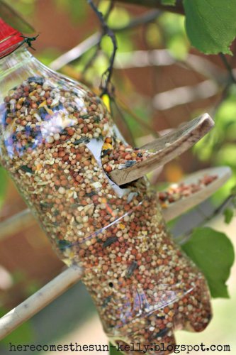 9) Soda Bottle Bird Feeder, 10) Tea Cup Bird Feeder, 11) Tea Cup Candle Sconce Bird Feeder, 12) Bird and Butterfly Water Feeder, 14) Acorn Bird Feeder, 15) Pine Cone Bird Feeders, 16) Glass Shade Bird Feeder, These DIY Bird Feeders Will Fill Your Garden with Song