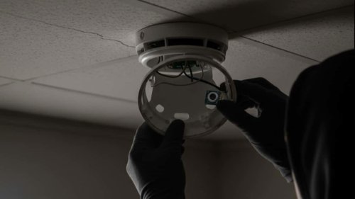 Smoke detectors Smoke detectors are among the most common hiding places for cameras. Positioned on ceilings or high walls, they provide a clear and wide view of the entire room. Because their design already includes small holes and sensors, a miniature lens can easily be hidden without drawing attention., Alarm clocks Placed conveniently on bedside tables, alarm clocks are strategically located to face the bed. A camera can be hidden behind the digital display or within the speaker grille. If an alarm clock looks unfamiliar or oddly positioned, it may be worth examining closely., Electrical outlets Electrical outlets are discreet locations for tiny pinhole cameras. These spots offer both concealment and continuous power. If an outlet appears newly installed, slightly misaligned, or has an unusual hole or mark, it could be hiding a lens., USB chargers and power adapters Modified USB adapters or charging plugs can double as recording devices. These items are particularly deceptive because travelers often plug their phones or laptops into them without suspicion. Always use your own trusted charger instead of the one provided in a room., Lamps and light fixtures Table lamps, wall sconces, or ceiling lights can be tampered with to conceal a camera within the shade or housing. Because lamps are close to beds or desks, they provide a convenient vantage point. Shine a flashlight into the fixture&mdash;camera lenses may reflect light., Mirrors Two-way mirrors are another common method of concealing cameras. You can test a mirror by placing your fingertip on it: if your reflection directly touches your finger with no visible gap, it might be a two-way mirror. In that case, report it immediately., Wall d&eacute;cor Picture frames, paintings, or decorative wall art can easily hide a camera behind the glass or inside the frame&rsquo;s border. Cameras placed in these objects usually target areas like the bed, bathroom entrance, or changing zone., Clothes hooks Small wall-mounted hooks, especially those placed near the shower or changing area, have been found to contain miniature cameras. Many spy cameras are sold online disguised as ordinary hooks, making them difficult to spot at first glance., Stuffed toys or decorative pillows In certain cases, hidden cameras have been placed inside soft furnishings or plush toys left on the bed or couch. Because they look harmless and are often decorative, these items rarely raise suspicion., Air vents and filters The grilles of air conditioning or heating vents offer a concealed space for cameras. These vents are often directed toward the main area of the room, providing a wide-angle view. A flashlight inspection may reveal small reflective lenses behind the slats, How to stay protected Travelers are advised to inspect their rooms thoroughly upon arrival. Turn off the lights and use a flashlight or your phone&rsquo;s camera to scan for reflections from hidden lenses. You can also check the hotel&rsquo;s Wi-Fi network for unfamiliar connected devices. If you find something suspicious, avoid tampering with it&mdash;report it immediately to hotel management and local authorities., Hidden cameras in hotel rooms: 10 common hiding spots travellers should check and how to stay protected